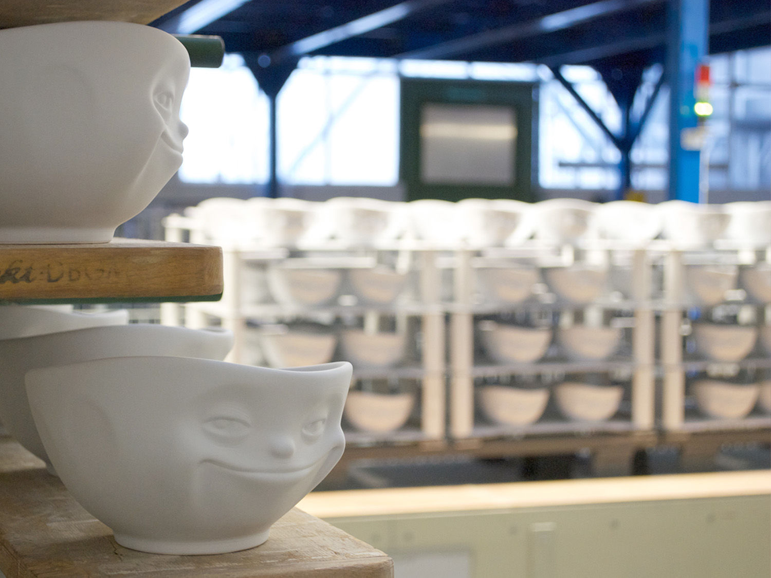 Aktuell kommt mit der „amüsierten“ Blumenvase das bereits zweite Deko-Objekt aus der TASSEN Kollektion auf den Markt und etabliert diese neue Produktkategorie als feste Größe im Angebot. Und für 2017 ging auch ein lang gehegter Wunsch der Fans in Erfüllung: TASSEN mit bunten Augen. „Produktionstechnisch ebenfalls enorm aufwändig, da die Farbe der Augen nicht einfach aufgepinselt werden kann, sondern lebensmittelgerecht mehrere tausend Spülmaschinengänge halten muss“, erklärt Ralph Engelmann von der BHS, die auch für die bunten Augen eine spezielle Methode zu deren Aufbringung entwickelt hat. In limitierter Auflage erschienen waren die Schalen mit bunten Augen ein absoluter Hit bei den Fans – und innerhalb kürzester Zeit restlos ausverkauft. Seitdem legen BHS und FIFTYEIGHT PRODUCTS nach und befriedigen nach besten Kräften die Nachfrage. „Wir wachsen ständig an den Herausforderungen und entwickeln aufgrund der Ideen von FIFTYEIGHT neue Lösungen im Produktionsbereich, um den Anforderungen gerecht zu werden“, sagt Ralph Engelmann. Neben der reinen Herstellung übernimmt BHS auch die Logistik, Mengenplanung sowie das Supply Chain Management für FIFTYEIGHT PRODUCTS – ebenfalls ein Alleinstellungsmerkmal der Produktion „Made in Germany“. Hierzu Marc Eckart von FIFTYEIGHT PRODUCTS: „Die Geschäftsbeziehung basiert auf gegenseitigem Vertrauen und wir freuen uns, unsere oft doch sehr abgefahrenen Ideen mit einem handwerklich unglaublich kompetenten Partner in emotional ansprechende Porzellanprodukte umsetzen zu können. Davon hätten wir noch vor wenigen Jahren nur geträumt.“